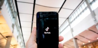 Man holding a smartphone with TikTok on it