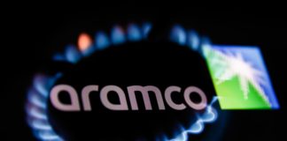 Flames from a gas burner and Aramco logo displayed on a phone screen