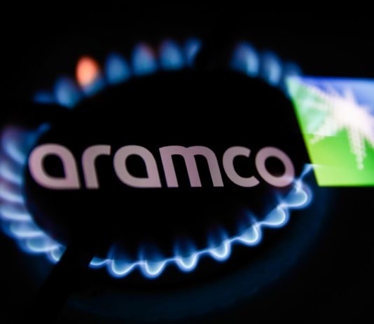 Flames from a gas burner and Aramco logo displayed on a phone screen
