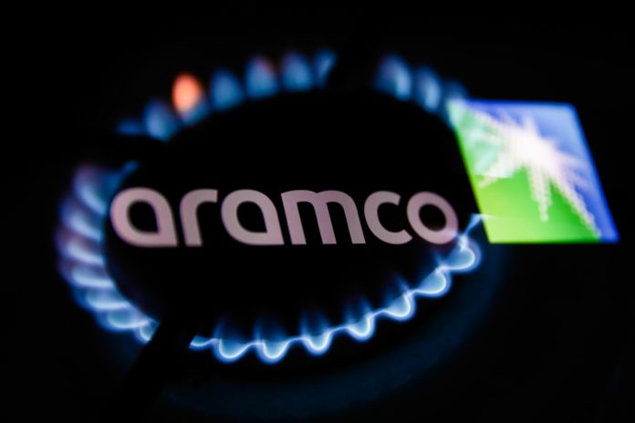 Flames from a gas burner and Aramco logo displayed on a phone screen